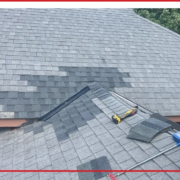 A section of replaced shingles on a house roof.