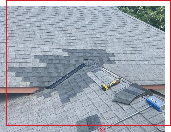 A section of replaced shingles on a house roof.