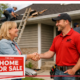 A contractor shaking hands with a homeowner in front of a house for sale.
