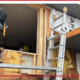 A home exterior restoration team works on repairing a house that rotted underneath its siding.