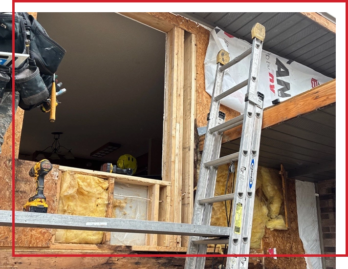 A home exterior restoration team works on repairing a house that rotted underneath its siding.