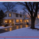 A house with the lights on inside during winter.